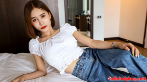 Pretty and passable TS lays on the bed wearing her blue jeans