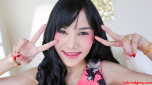 Playful Ladyboy smiles wide showing her braces and peace sign